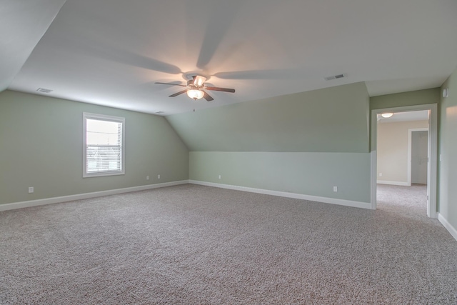 additional living space with ceiling fan, light colored carpet, and vaulted ceiling