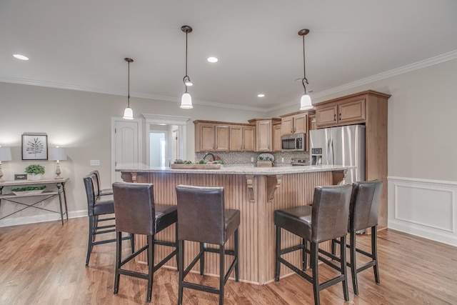 kitchen with pendant lighting, crown molding, and stainless steel appliances