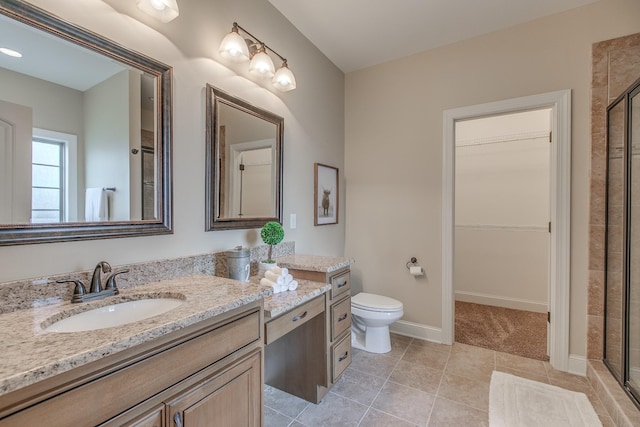 bathroom featuring tile patterned floors, vanity, toilet, and an enclosed shower