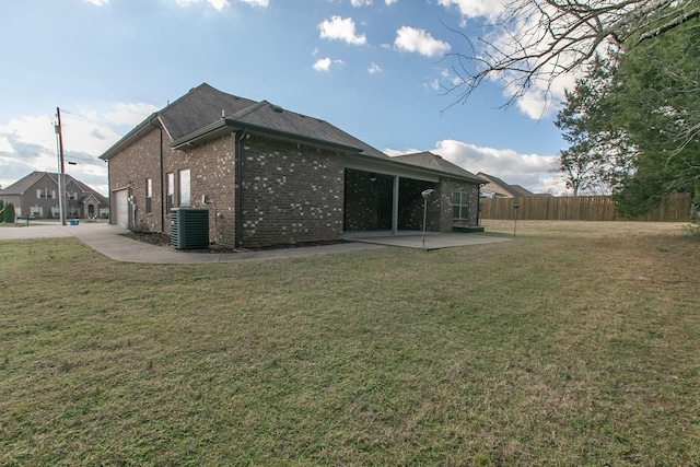 rear view of property with central AC unit, a yard, and a patio