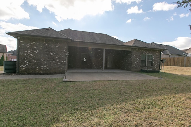 back of property with a lawn, central air condition unit, and a patio