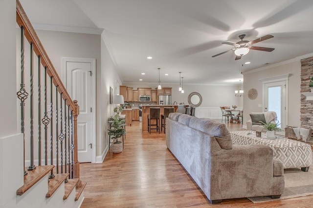 living room featuring ceiling fan, light hardwood / wood-style floors, and ornamental molding