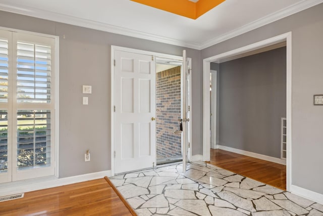 foyer with crown molding and light hardwood / wood-style floors