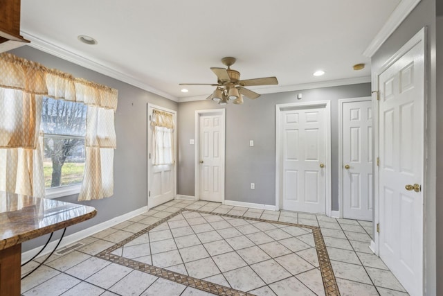 tiled foyer entrance with ceiling fan and crown molding