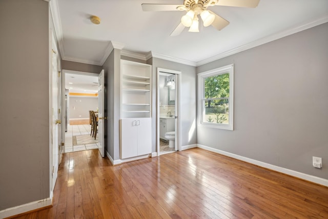 unfurnished bedroom with ensuite bathroom, ornamental molding, ceiling fan, sink, and wood-type flooring