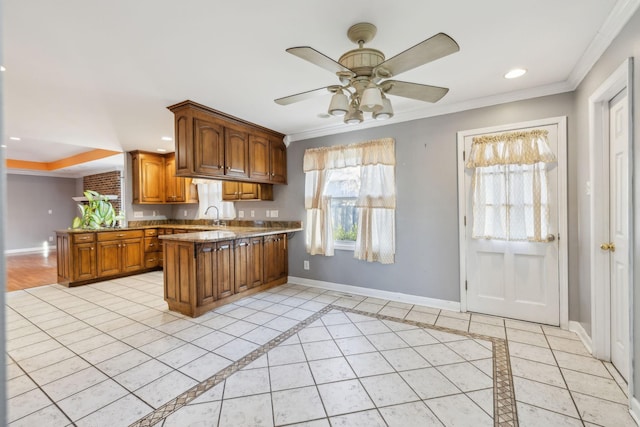 kitchen with kitchen peninsula, ceiling fan, crown molding, sink, and light tile patterned flooring