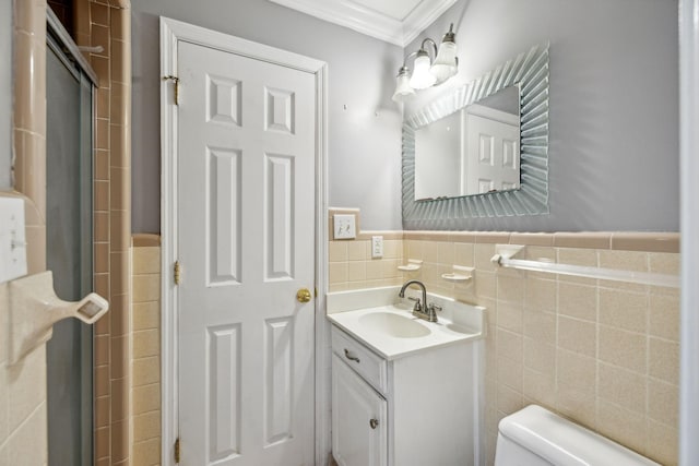 bathroom featuring toilet, vanity, tile walls, and ornamental molding