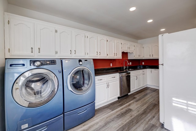 laundry room featuring washer and dryer, wood-type flooring, and sink