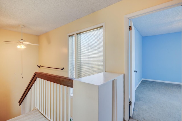 hall with carpet flooring and a textured ceiling