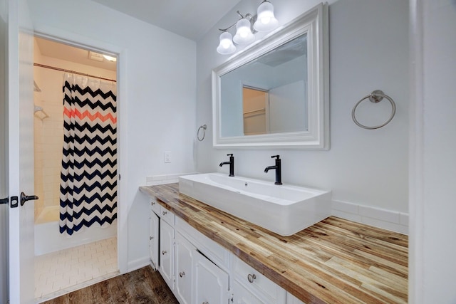 bathroom with wood-type flooring, vanity, and shower / bathtub combination with curtain