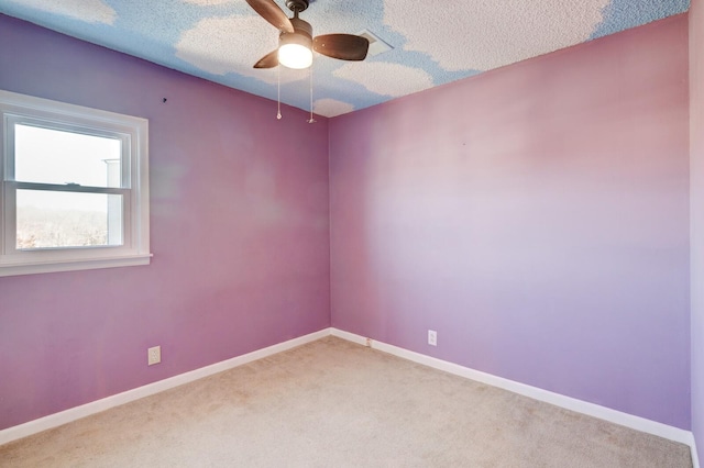 carpeted empty room with ceiling fan and a textured ceiling