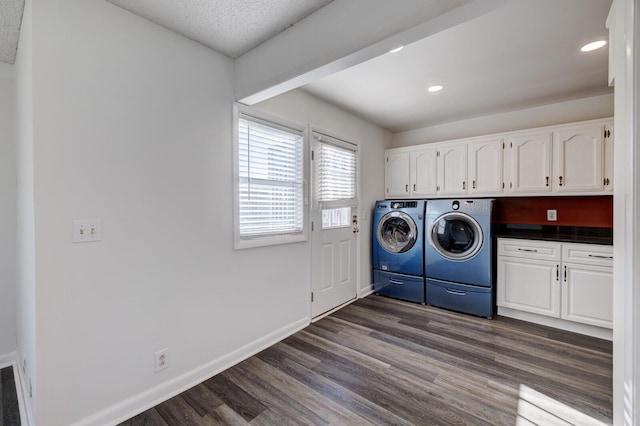 laundry area featuring cabinets, dark hardwood / wood-style floors, washing machine and dryer, and a textured ceiling