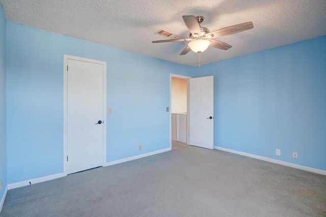 carpeted spare room with ceiling fan and a textured ceiling