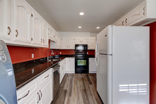 kitchen featuring sink, dark hardwood / wood-style flooring, dark stone countertops, white cabinets, and black appliances