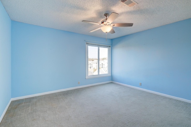 carpeted empty room with ceiling fan and a textured ceiling