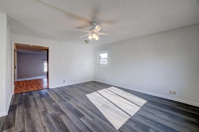 unfurnished room with ceiling fan, dark wood-type flooring, and a textured ceiling