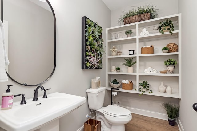 bathroom featuring sink, wood-type flooring, and toilet