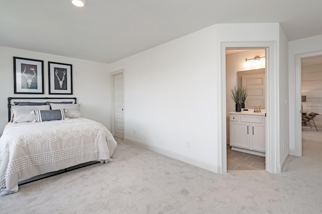 carpeted bedroom featuring connected bathroom and sink