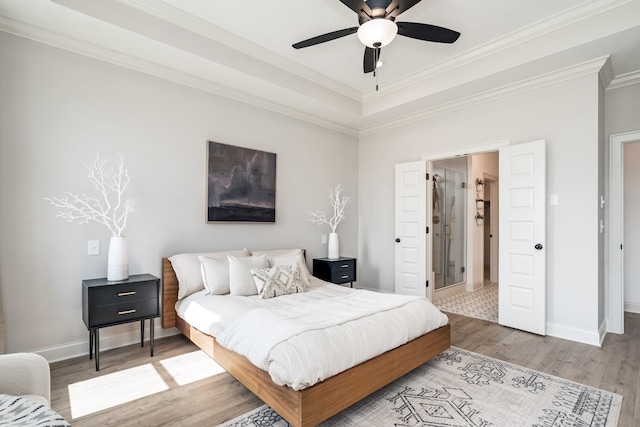 bedroom featuring a raised ceiling, ceiling fan, wood-type flooring, and ornamental molding