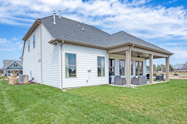 back of property with a lawn, central air condition unit, an outdoor hangout area, ceiling fan, and a patio