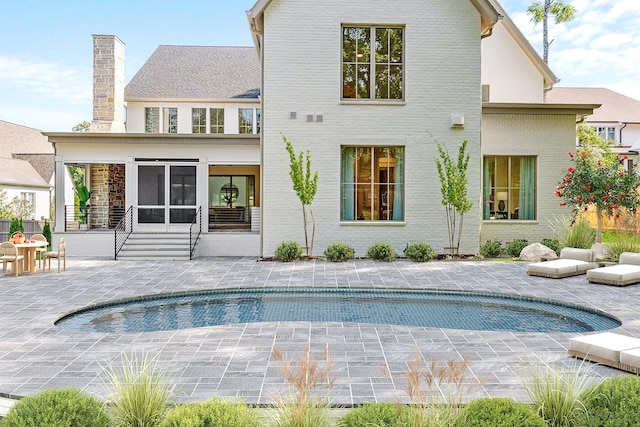 rear view of property featuring a patio area and a sunroom