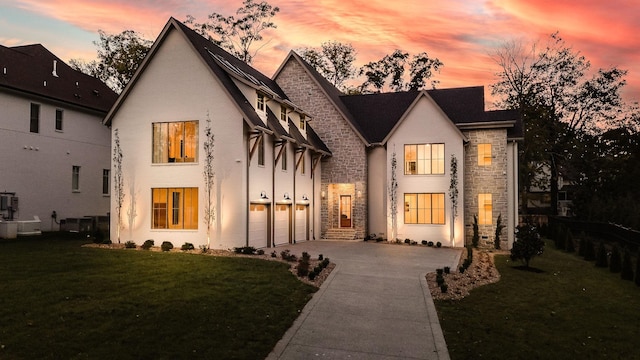 view of front facade featuring a garage, central AC unit, and a lawn