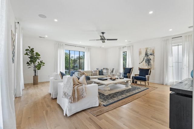 living room featuring ceiling fan and light hardwood / wood-style floors