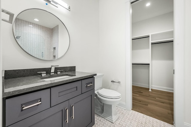 bathroom featuring tile patterned floors, vanity, toilet, and walk in shower