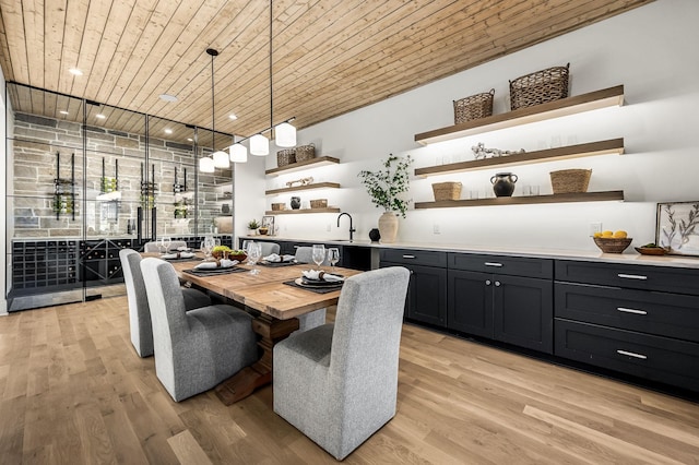 dining space with light wood-type flooring, track lighting, and sink