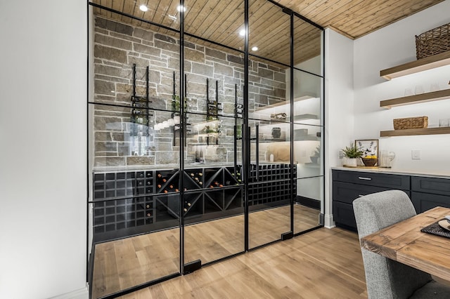 wine cellar with light hardwood / wood-style floors and wooden ceiling