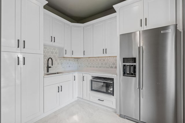 kitchen with white cabinets, sink, tasteful backsplash, stainless steel fridge with ice dispenser, and black microwave