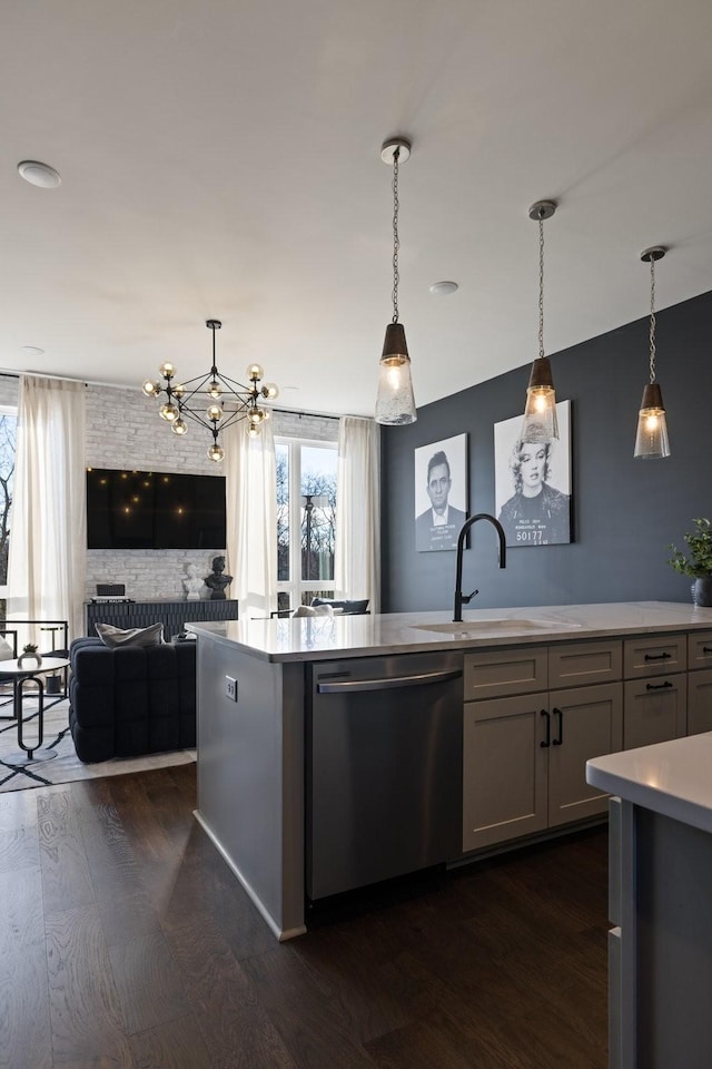 kitchen with sink, hanging light fixtures, stainless steel dishwasher, and dark hardwood / wood-style floors