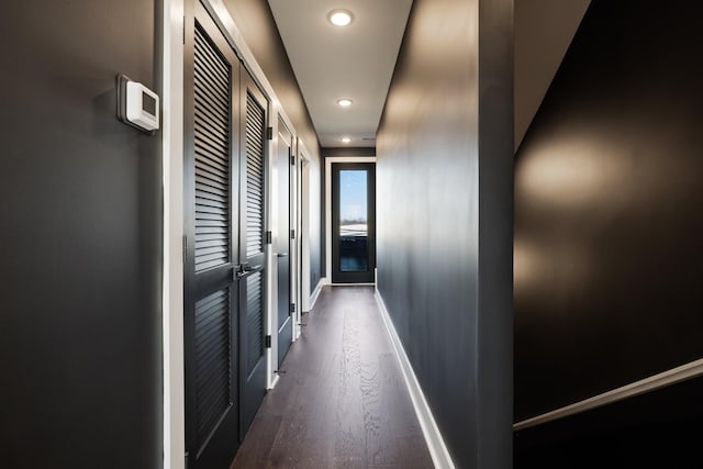 corridor with dark hardwood / wood-style flooring