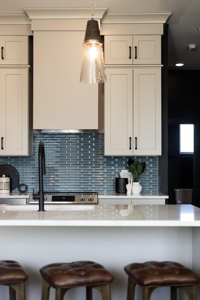 kitchen featuring a breakfast bar, pendant lighting, and tasteful backsplash