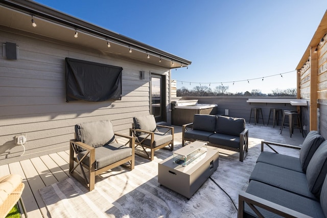 wooden deck featuring a hot tub, an outdoor hangout area, and exterior bar