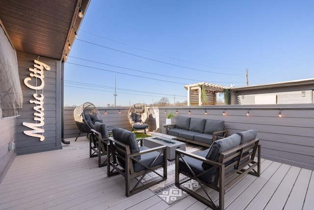 wooden deck with an outdoor living space with a fire pit