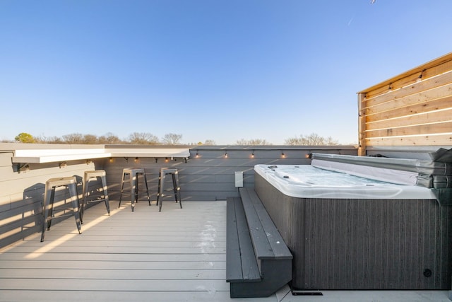 wooden terrace with exterior bar and a hot tub