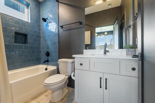 full bathroom featuring toilet, tiled shower / bath combo, and vanity