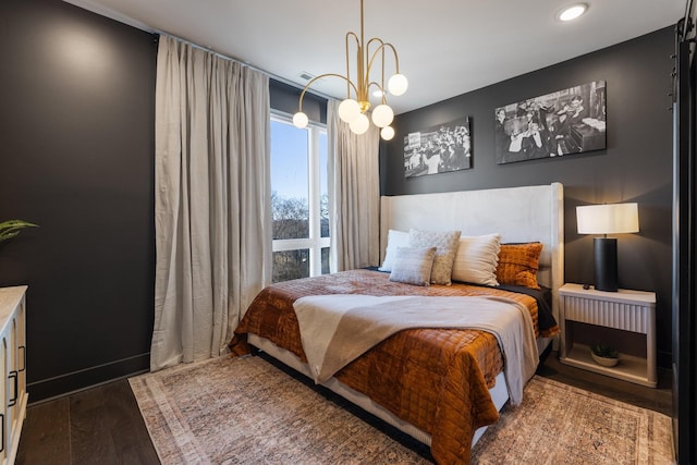 bedroom with dark hardwood / wood-style floors and a chandelier