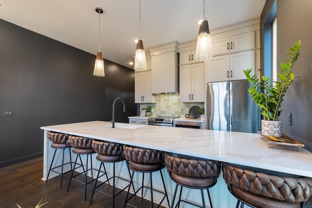 kitchen featuring appliances with stainless steel finishes, wall chimney range hood, sink, backsplash, and light stone counters