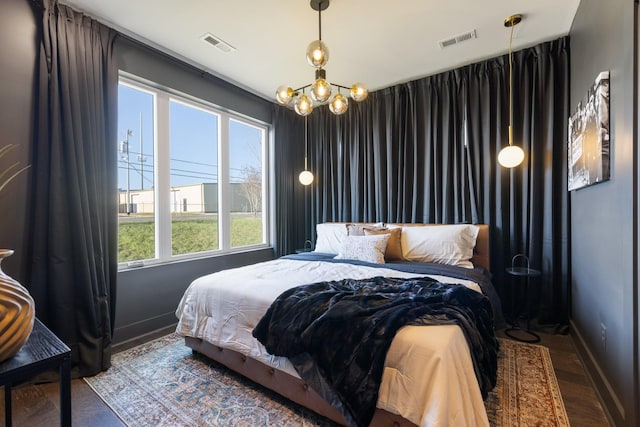 bedroom featuring hardwood / wood-style floors and a notable chandelier