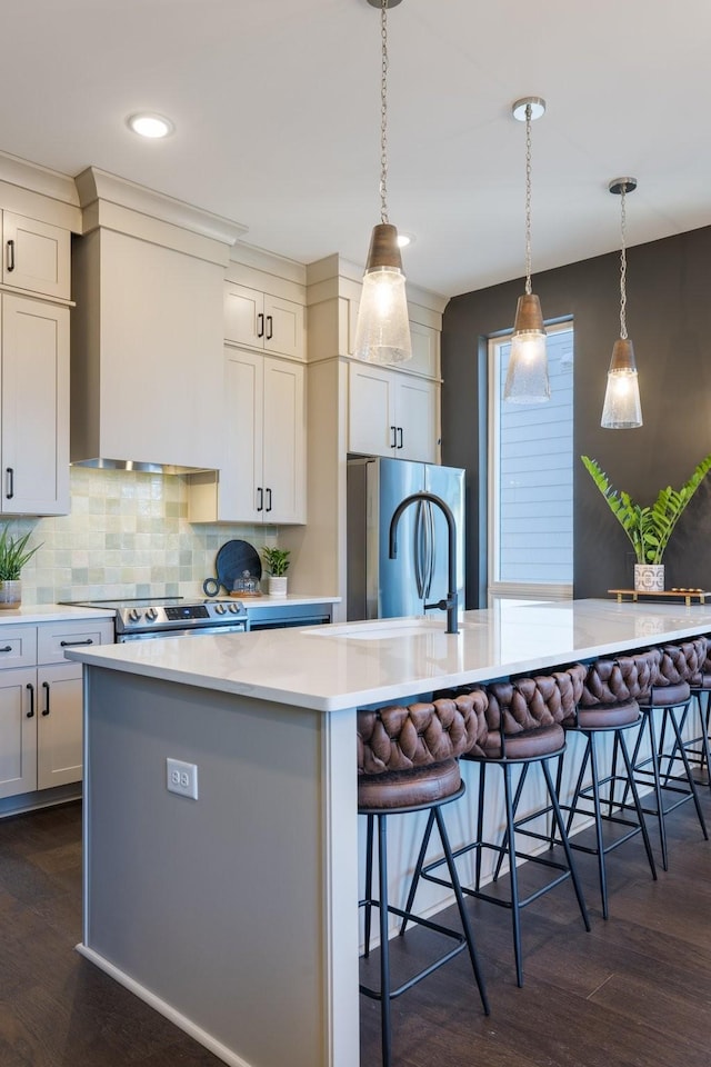 kitchen featuring a breakfast bar area, stainless steel appliances, dark hardwood / wood-style floors, and a spacious island