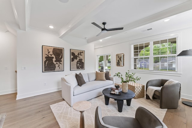 living room featuring beamed ceiling, light hardwood / wood-style floors, ceiling fan, and a healthy amount of sunlight