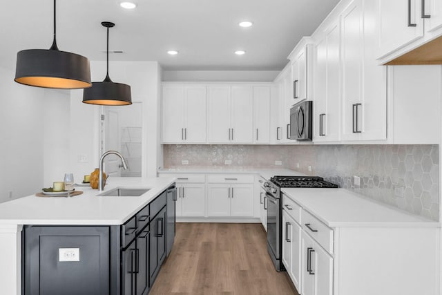 kitchen featuring sink, hanging light fixtures, stainless steel appliances, backsplash, and white cabinets