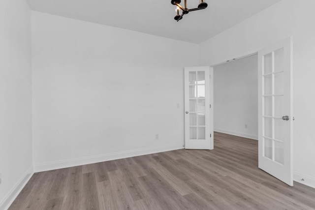 unfurnished room featuring french doors and light hardwood / wood-style floors