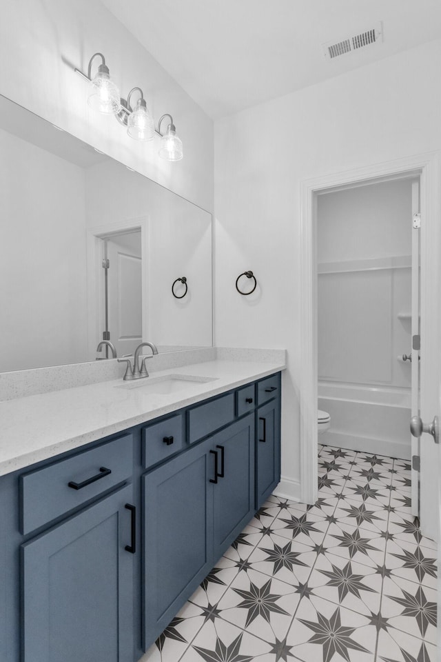 full bathroom featuring washtub / shower combination, vanity, and toilet