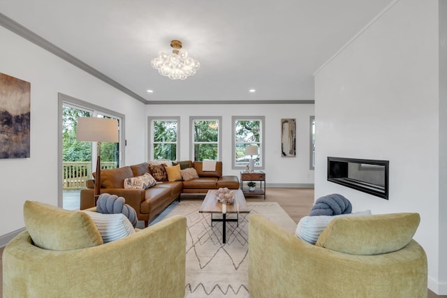 living room featuring light hardwood / wood-style flooring, a chandelier, and ornamental molding