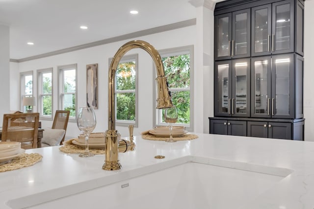 details with light stone counters, sink, and crown molding