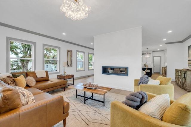 living room with a notable chandelier, light wood-type flooring, and crown molding