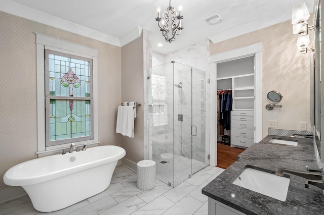 bathroom with plus walk in shower, vanity, an inviting chandelier, and crown molding